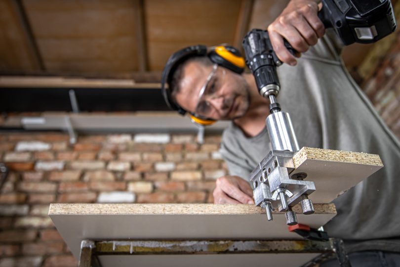 The carpenter works as a professional tool for drilling wood.